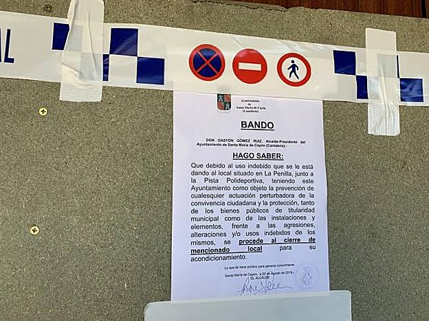 El bando colocado en la puerta del local clausurado con chapas de madera atornilladadas.