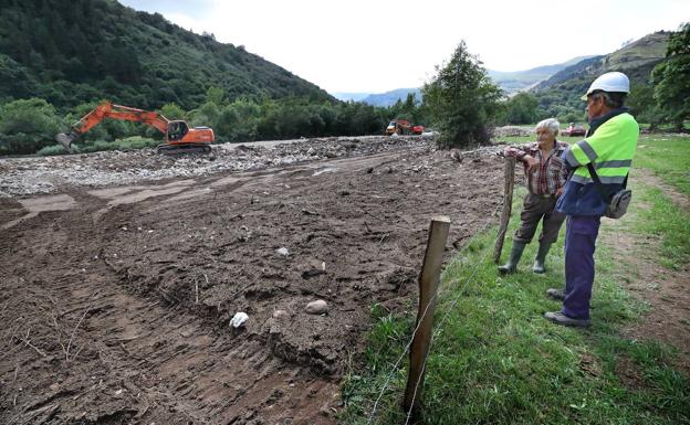 Un técnico, junto al dueño de una finca afectada por las inundaciones.