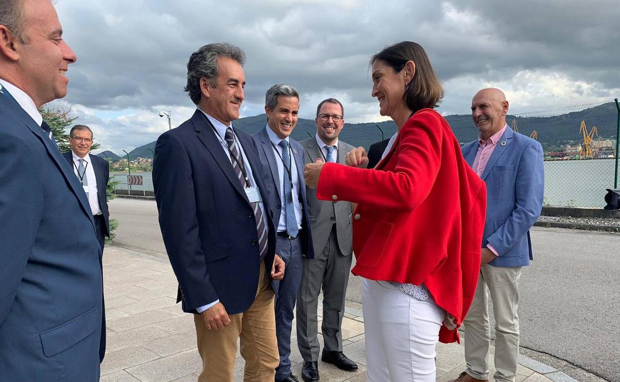 La ministra Reyes Maroto saluda al consejero de Industria, Francisco Martín, en presencia de Eduardo Echevarría y Pablo Zuloaga, entre otros.