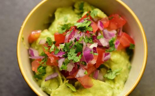 Guacamole casero con pico de gallo y cilantro.