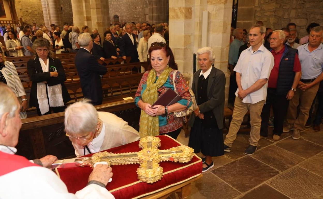 Los fieles muestran su devoción por la cruz. 