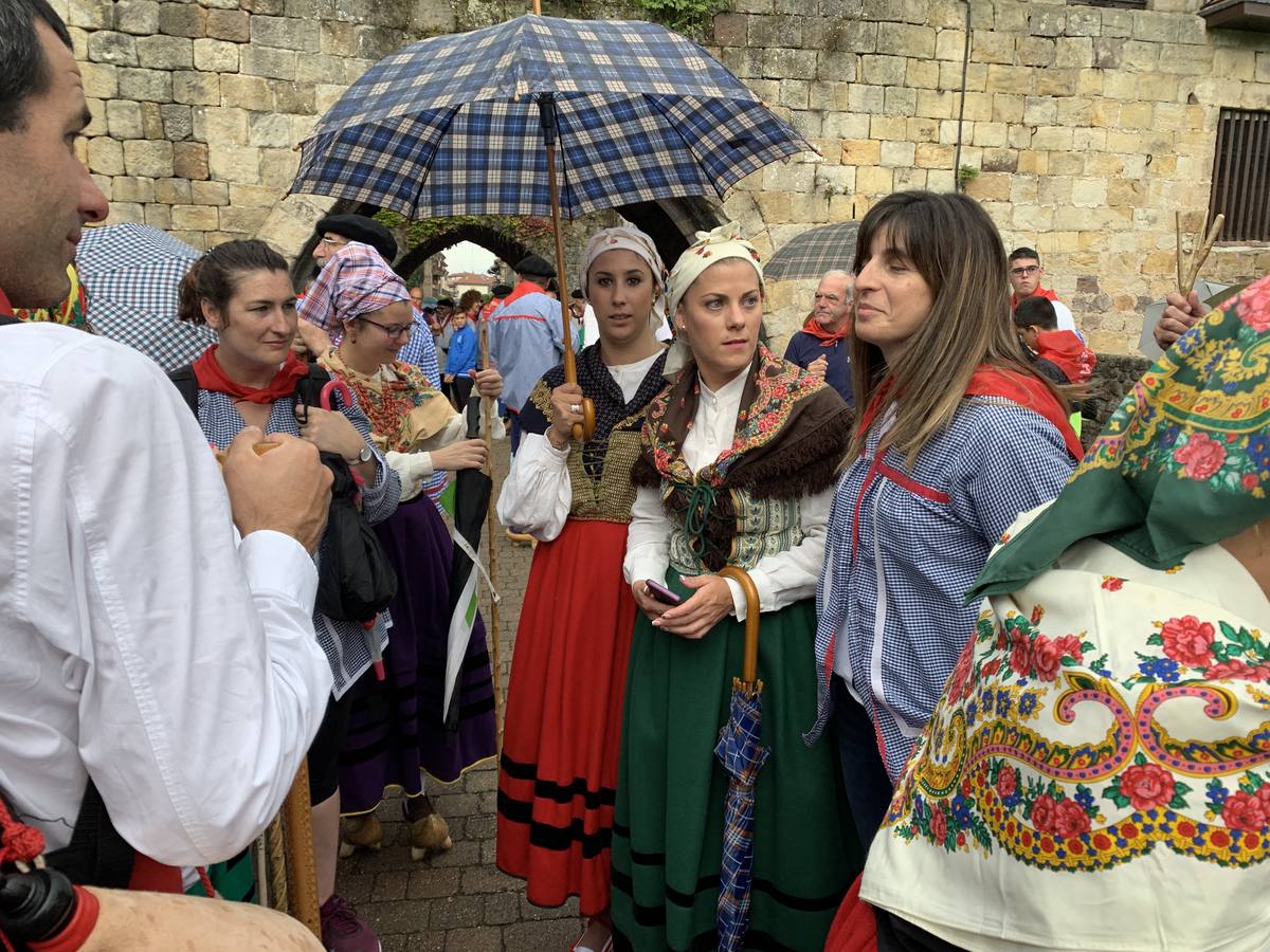 Los vecinos de Cartes tuvieron que sacar los paraguas para participar en el 'Día de las albarcas', caminando bajo la lluvia hasta Cohicillos