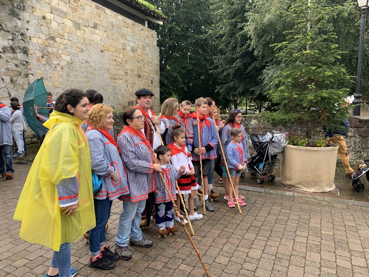Los vecinos de Cartes tuvieron que sacar los paraguas para participar en el 'Día de las albarcas', caminando bajo la lluvia hasta Cohicillos