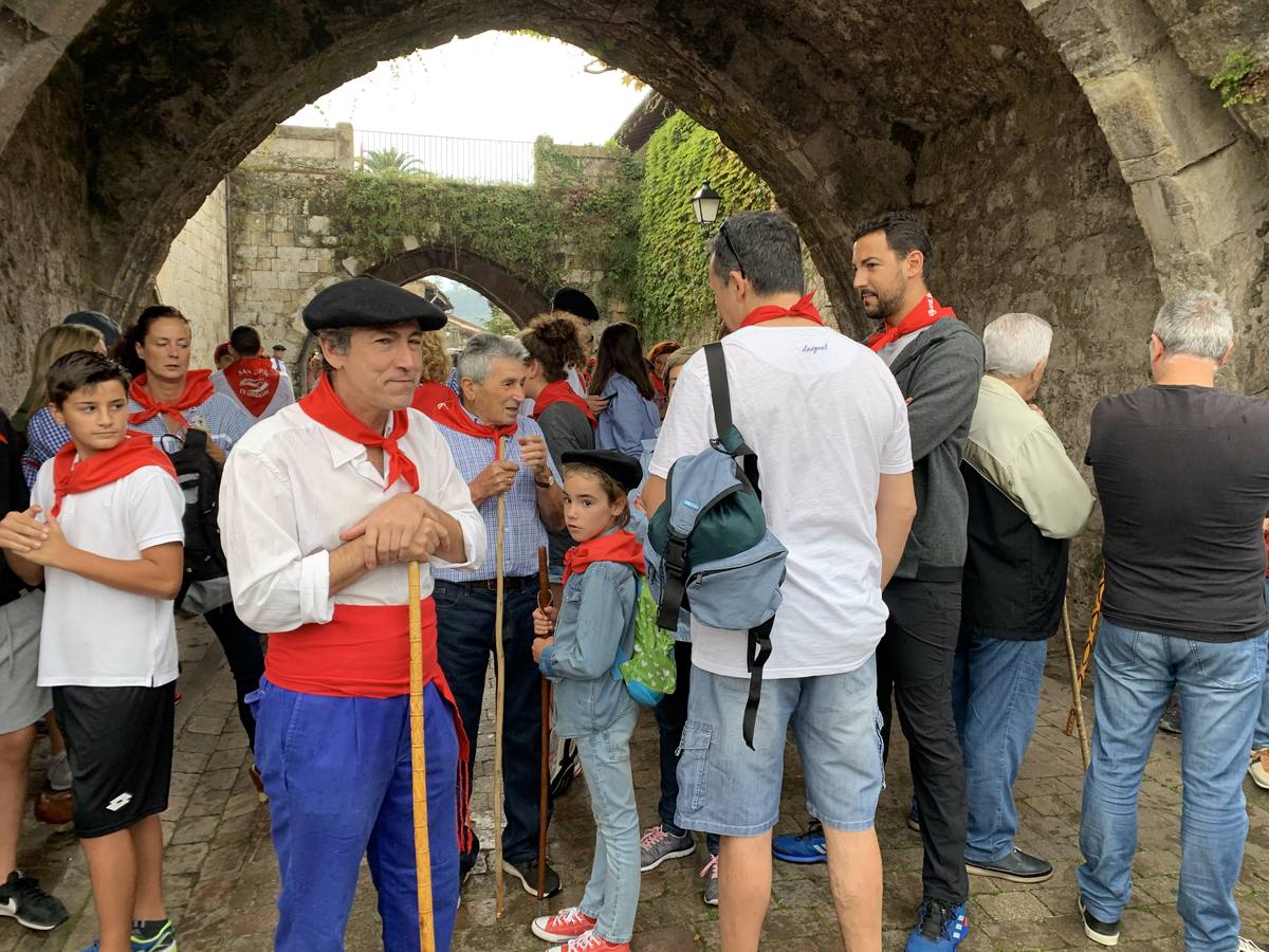 Los vecinos de Cartes tuvieron que sacar los paraguas para participar en el 'Día de las albarcas', caminando bajo la lluvia hasta Cohicillos