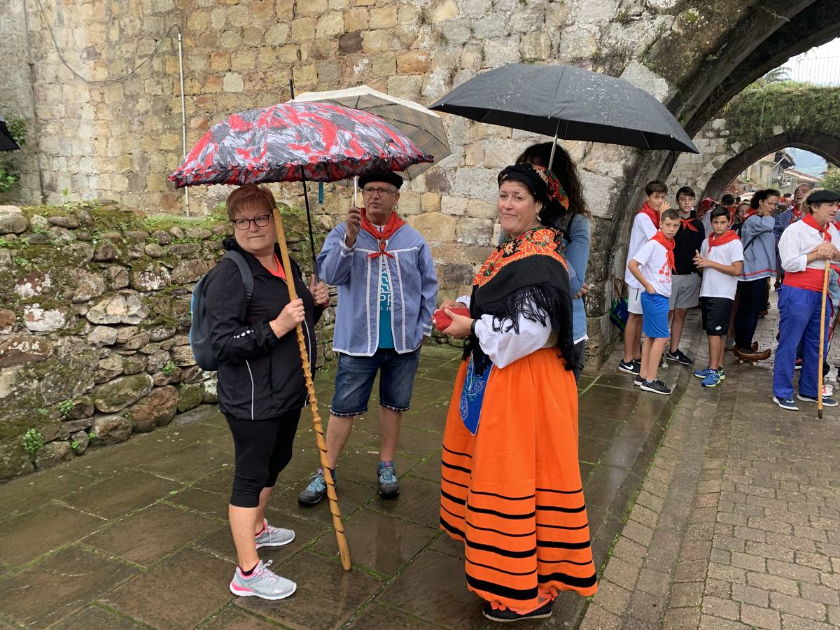 Los vecinos de Cartes tuvieron que sacar los paraguas para participar en el 'Día de las albarcas', caminando bajo la lluvia hasta Cohicillos