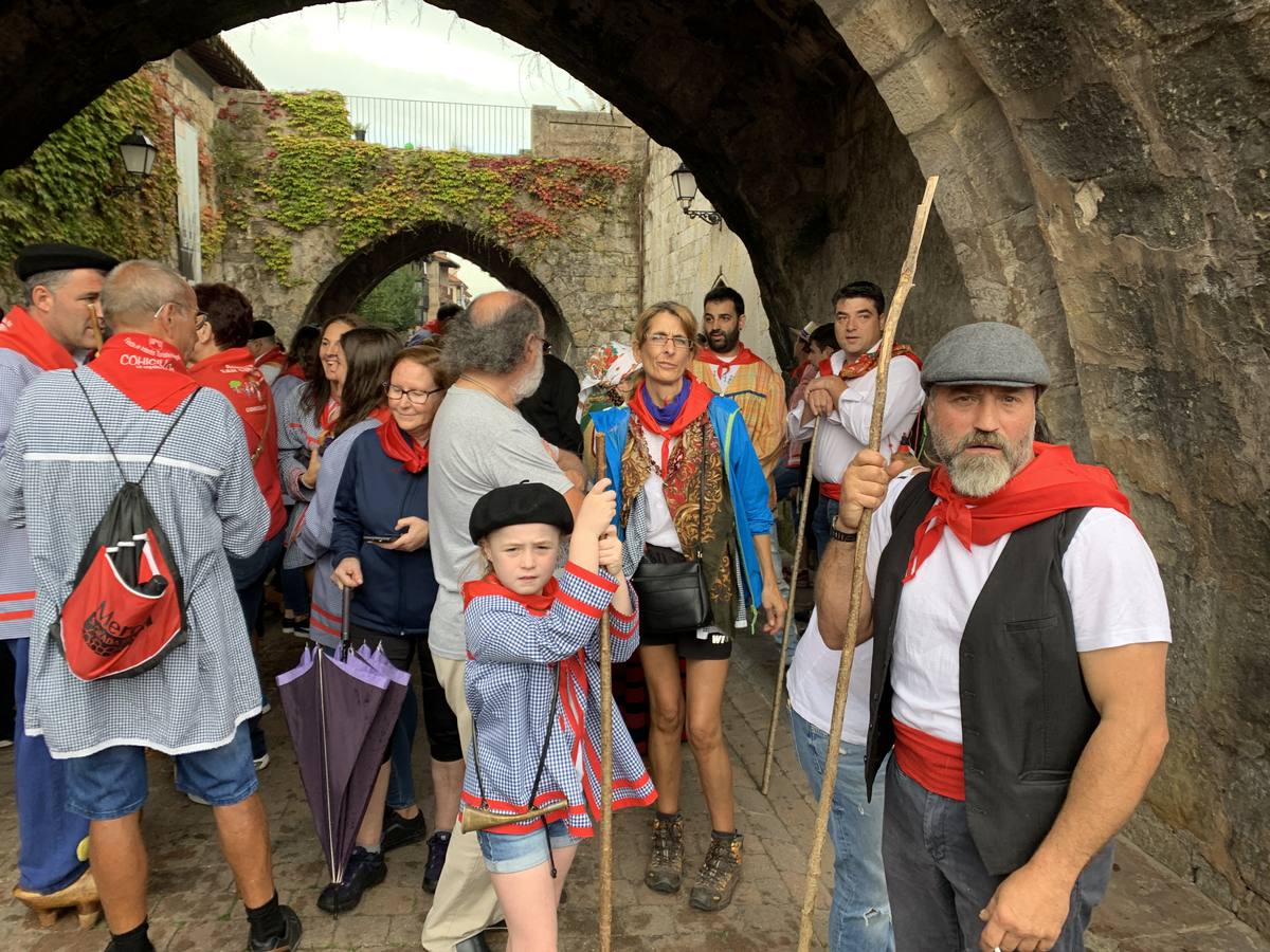 Los vecinos de Cartes tuvieron que sacar los paraguas para participar en el 'Día de las albarcas', caminando bajo la lluvia hasta Cohicillos
