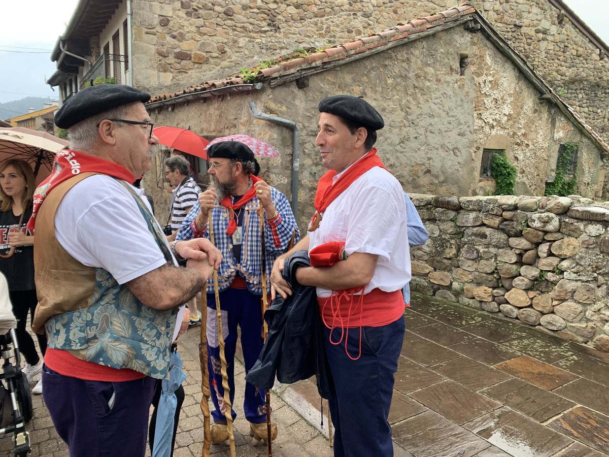 Los vecinos de Cartes tuvieron que sacar los paraguas para participar en el 'Día de las albarcas', caminando bajo la lluvia hasta Cohicillos
