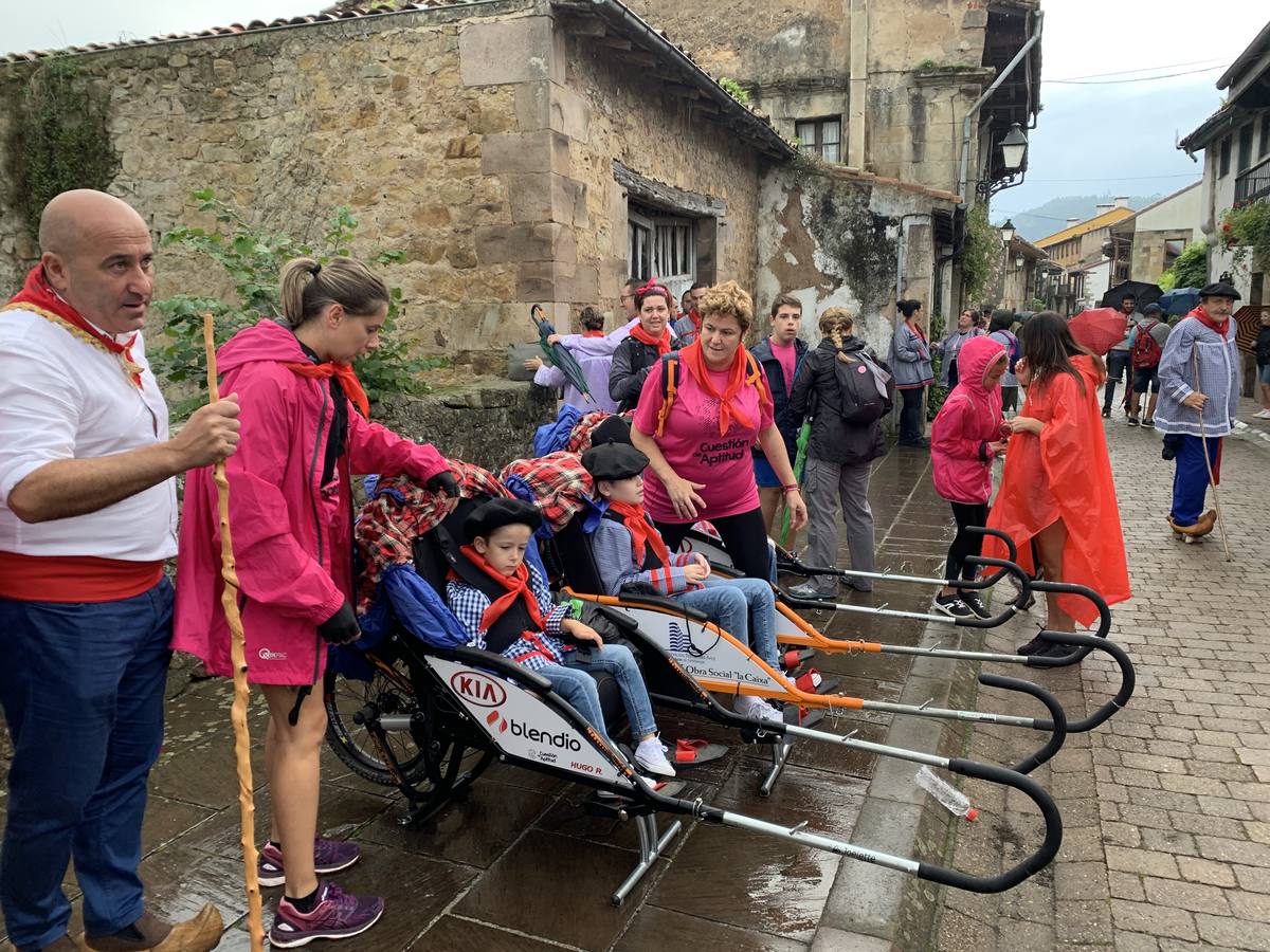Los vecinos de Cartes tuvieron que sacar los paraguas para participar en el 'Día de las albarcas', caminando bajo la lluvia hasta Cohicillos