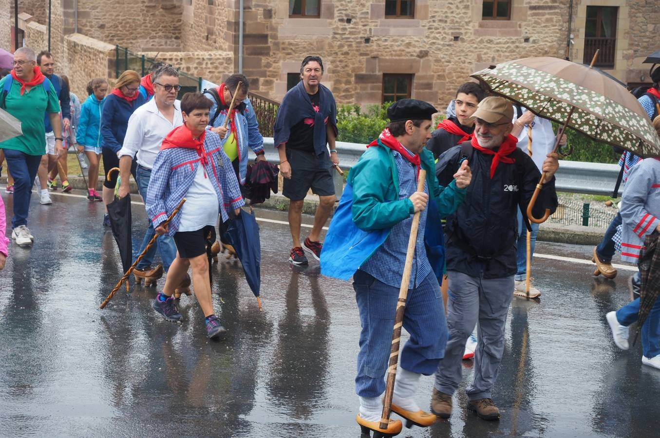 Los vecinos de Cartes tuvieron que sacar los paraguas para participar en el 'Día de las albarcas', caminando bajo la lluvia hasta Cohicillos