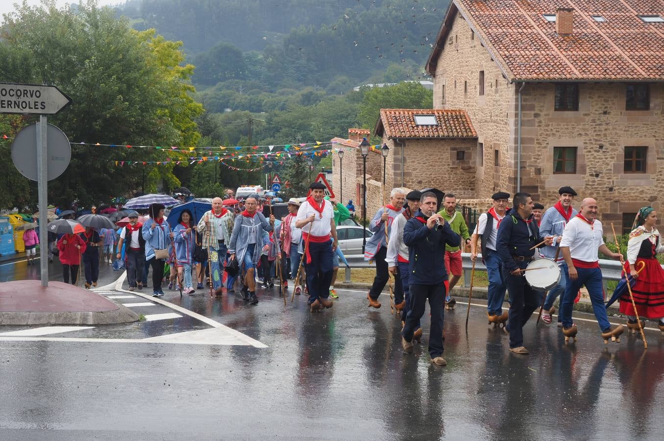 Los vecinos de Cartes tuvieron que sacar los paraguas para participar en el 'Día de las albarcas', caminando bajo la lluvia hasta Cohicillos