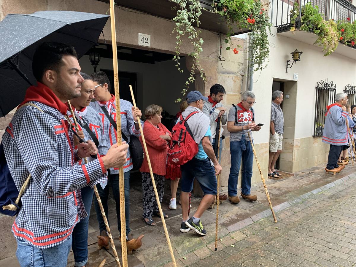 Los vecinos de Cartes tuvieron que sacar los paraguas para participar en el 'Día de las albarcas', caminando bajo la lluvia hasta Cohicillos