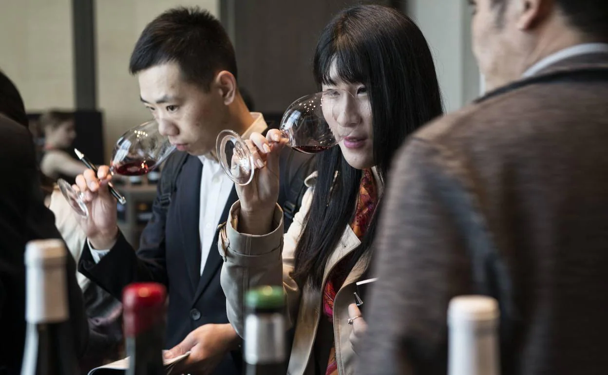 Varios ciudadanos chinos prueban vinos españoles durante una feria en Shanghái.