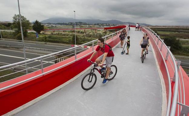 Los vecinos del municipio cruzan la pasarela ciclista sobre la autovía a su paso por las marismas de Alday. 