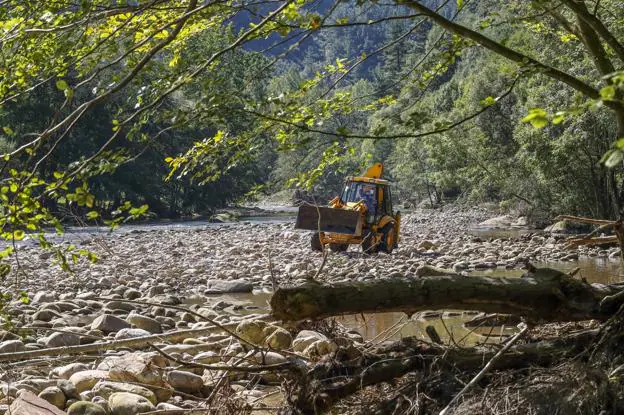  Tras la crecida. Un operario trabaja en la limpieza del río Saja, tras las riadas que sufrieron recientemente los municipios de la ribera, como consecuencia de la gota fría. 