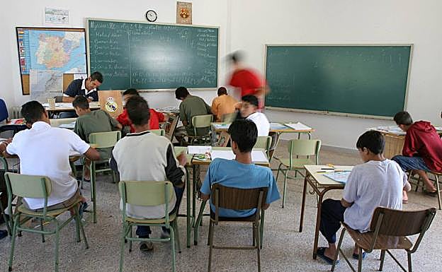 Un grupo de menores inmigrantes asiste a clase en un centro de acogida, donde participan en distintos programas de educación y entrenamiento de habilidades sociales. 