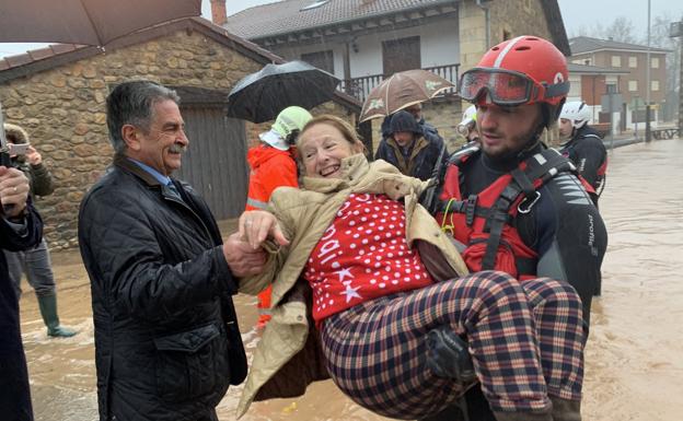 Josefa Gómez sale de su casa en los brazos de un bombero para caer en los del presidente Miguel Ángel Revilla. La fotografía se tomó el 24 de enero, en plena riada. Hoy, 5 de octubre, 'Pepita' sigue sin poder entrar.