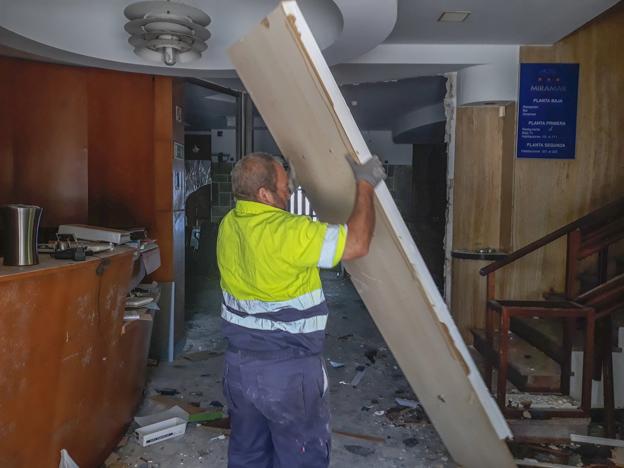 Un empleado de la empresa Tragsa procede a la retirada de parte del mobiliario del edificio. 