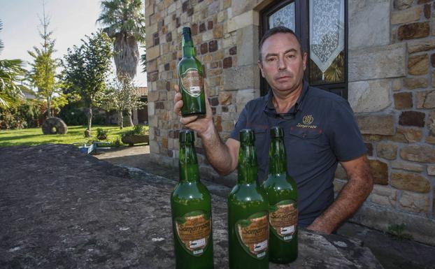 Jesús Gómez posa junto a las botellas de la polémica en las instalaciones de Somarroza. 