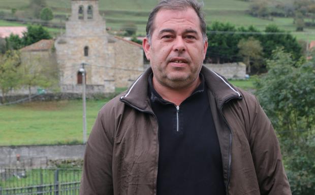 Eduardo Gutiérrez, con la iglesia de San Miguel de Aguayo al fondo. :