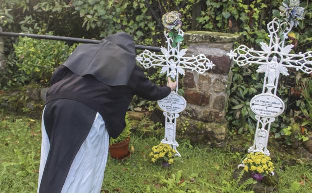 Sor Ana arregla la tumba de una de sus hermanas fallecida a la edad de 103 años. 