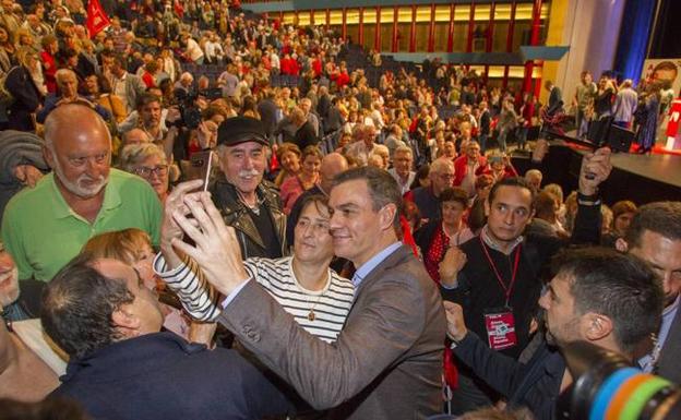 Pedro Sánchez se hace un autorretrato con una asistente al mitin en el Palacio de Festivales, rodeado de militantes.