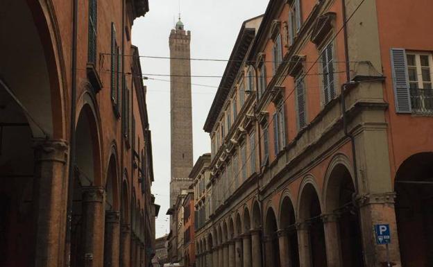 Imagen principal - Arriba, una de las calles de Bolonia con la torre Asinelli al fondo. Abajo, a la izquierda, el Palacio Comunale; y a la derecha, el edificio de la Cámara de Comercio. 