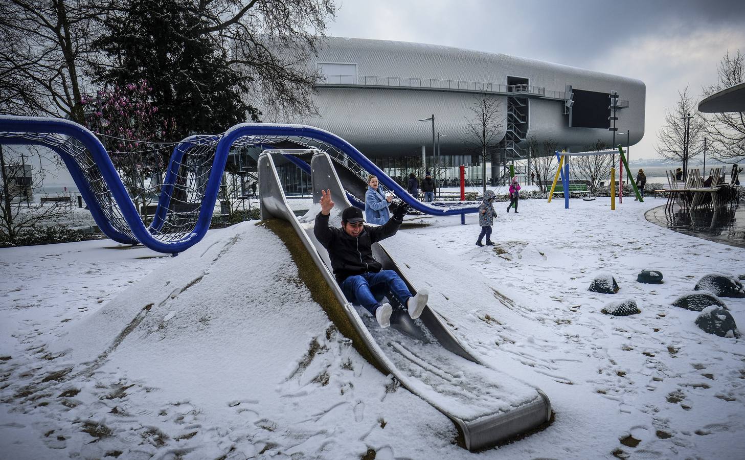 Un chico se tira por un tobogán delante del Centro Botín en los jardines de Pereda durante una inusual nevada en Santander. Santander 28-02-2018