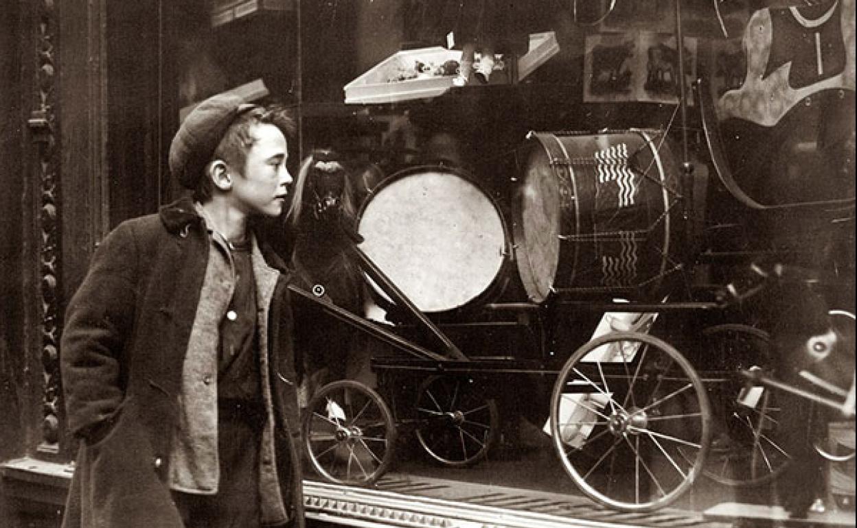 Un niño con mirada de deseo en un escaparate.