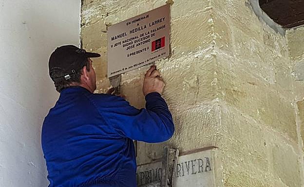 Imagen de la retirada, en 2018, de la placa falangista aparecida en el pórtico de la iglesia de San Andrés de Ambrosero, en homenaje al político falangista Manuel Hedilla Larrey.