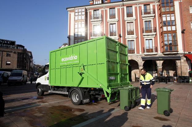 Un operario realiza la recogida de envases de vidrio en la céntrica Plaza Baldomero Iglesias. 