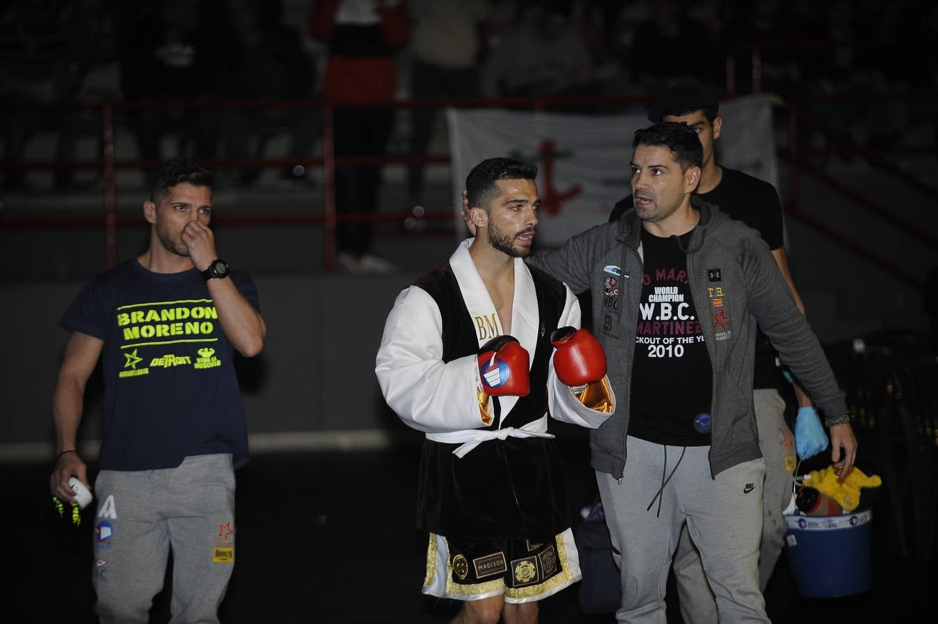 Una nueva velada con el Niño como protagonista y de nuevo un excepcional ambiente en el Vicente Trueba, con colas ya desde primera hora, antes de que comenzara la jornada, que tenía previsto su primer combate para las ocho de la tarde. Y ya desde el principio las gradas del pabellón mostraban una buena afluencia, destinada a multiplicarse para la cita estelar de la noche. También en los alrededores se aprecia el movimiento propio de estas ocasiones, en una noche de sábado en la que el deporte convive con la jornada de puente y fiestas en la Plaza Mayor y la Plaza Roja. En total, más de 2.000 personas para seguir con atención la tercera defensa del título del campeón torrelaveguense, siempre volcado con una ciudad que sabe devolverle el cariño.