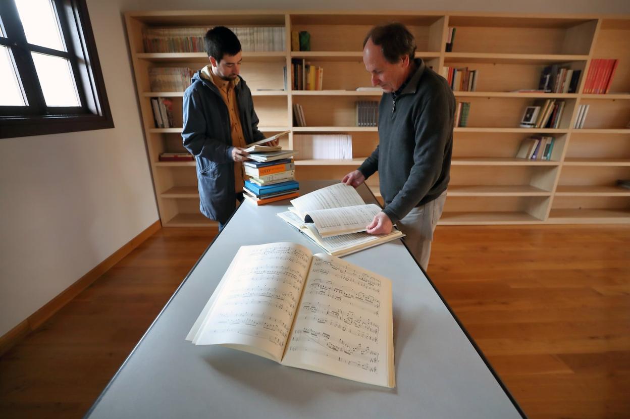 Enrique Campuzano y un vecino de Casar ordenan partituras en la biblioteca del museo.