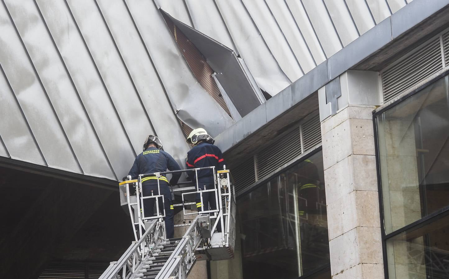 Los bomberos de Santander, asegurando las planchas metálicas del CEAR de Vela, desprendidas por el viento.