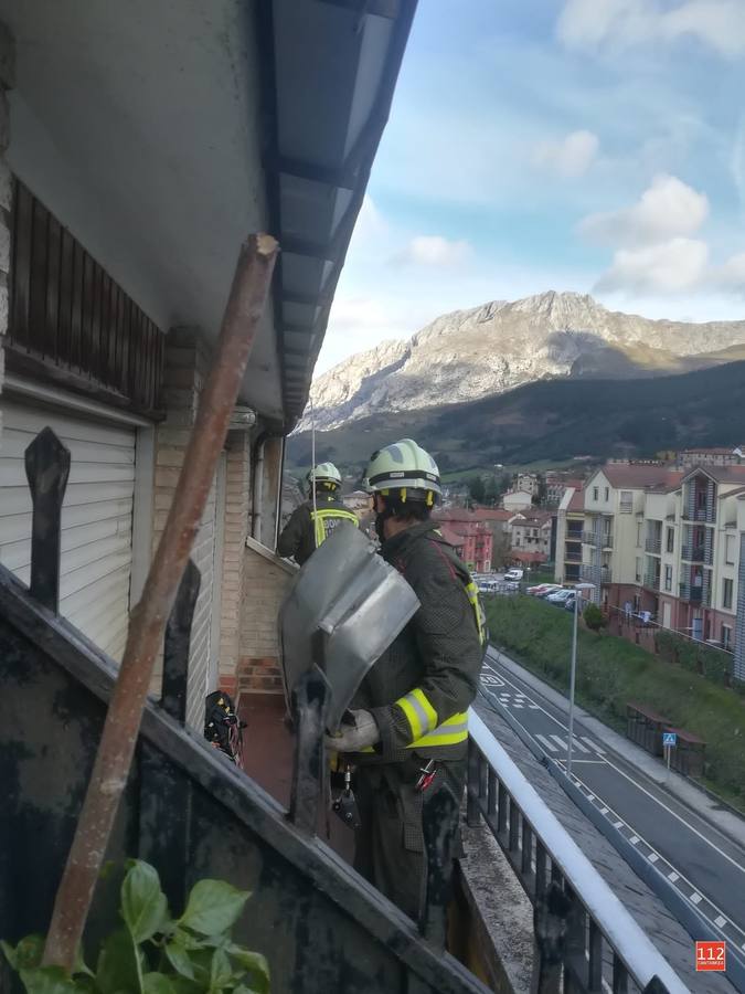 Bomberos de Tama asegurando varias chapas a punto de caer en la vía pública en Ojedo (Cillorigo De Liébana)