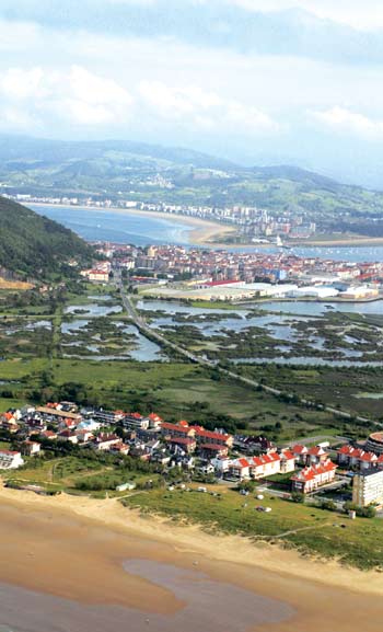 Vista de la playa de Berria, con las marismas y la villa de Santoña al fondo.