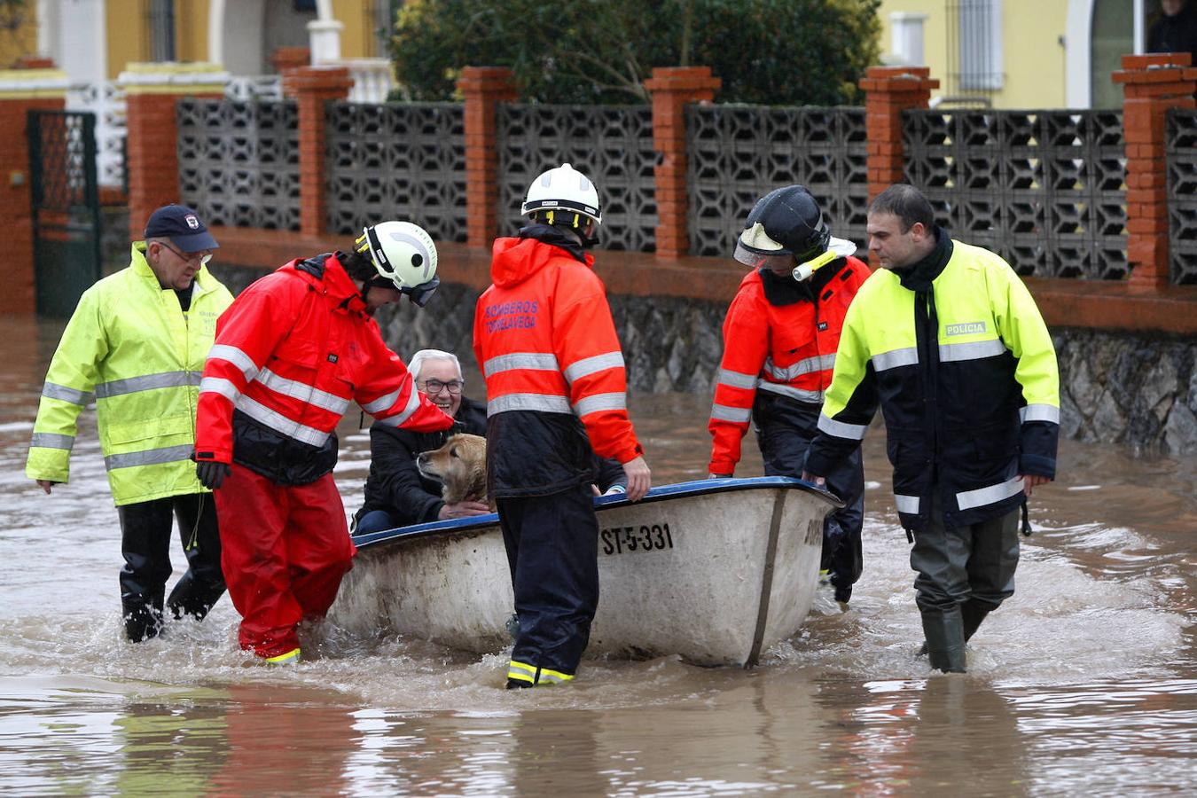 Vecinos de los chalés Tortuga son evacuados en barca por bomberos y miembros de Protección Civil tras las inundaciones provocadas por el desbordamiento del río Besaya en Torrelavega, a finales de enero.