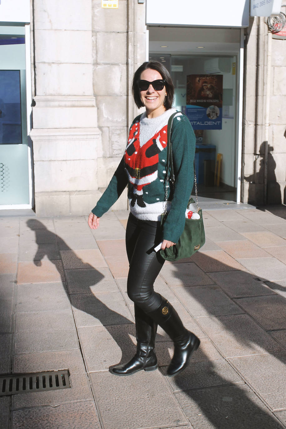 Jersey navideño, pantalón cuero negro, botas con apliques y accesorios dorados.