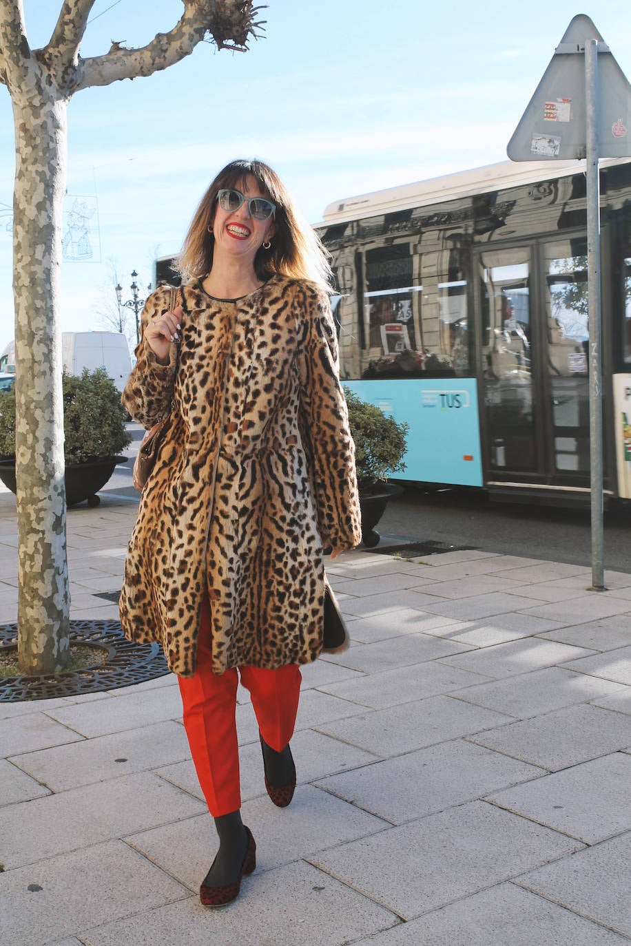 Abrigo 'animal print', combinado con un pantalón 'paper bag' rojo y accesorios dorados.