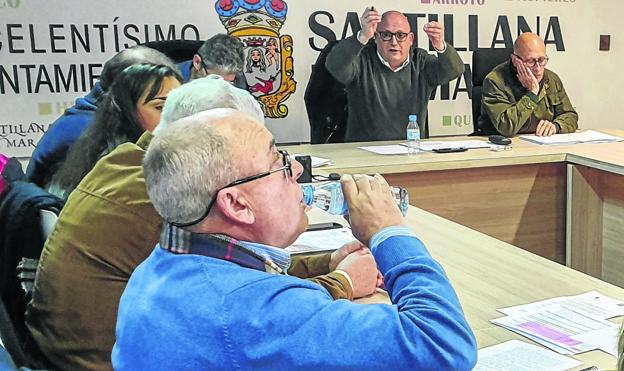 El alcalde de Santillana, al fondo, sobresaltado tras las críticas al presupuesto del teniente alcalde, en primer plano (bebiendo).