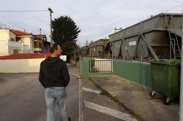 El presidente de la Asociación de Vecinos Santa María de Barreda muestra los vagones estacionados junto a las casas. 