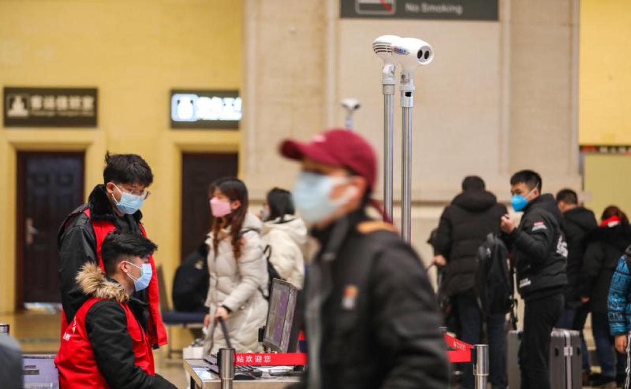 Parajeros con mascarillas en una estación de tren en Wuhan. 