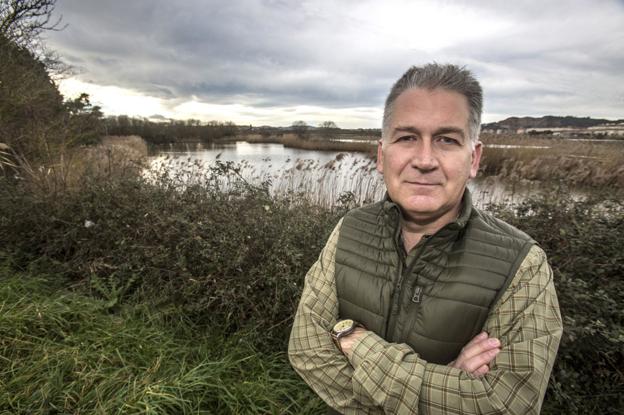 El presidente de la Fundación Naturaleza y Hombre, Carlos Sánchez, posa frente a las Marismas de Alday, en El Astillero. 