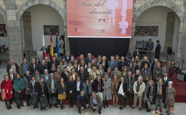 Los docentes jubilados posan en el Parlamento junto a los representantes institucionales.