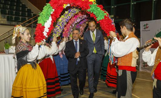 Revilla y López Estrada pasan bajo los arcos de la Agrupación de Danzas de Tanos.