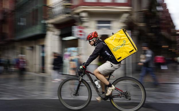 Un repartidor en plena jornada laboral recorre la ciudad en bicicleta.