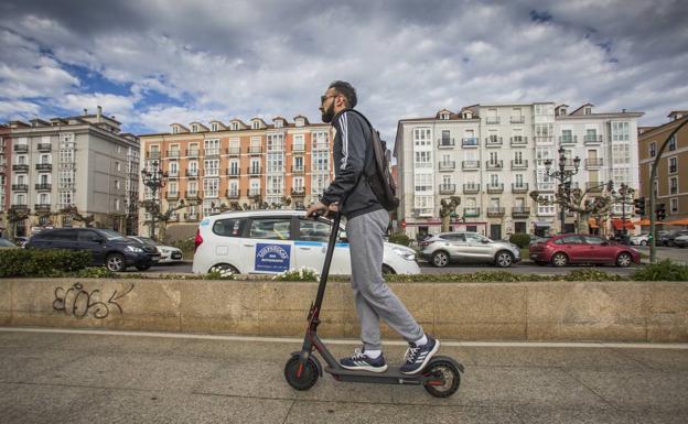 Un joven se desplaza en su patinete eléctrico por el carril bici paralelo al Paseo de Pereda.