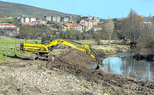 Una máquina excavadora realiza trabajos de limpieza en el cauce del río Híjar en las inmediaciones de Reinosa. 