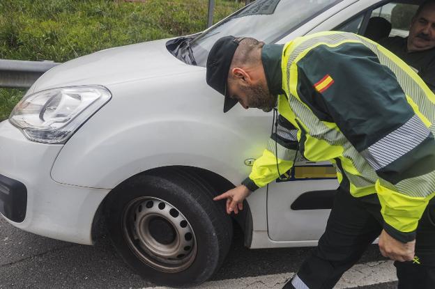 Un guardia civil comprueba el estado de los neumáticos de un turismo en uno de los controles. :: sane