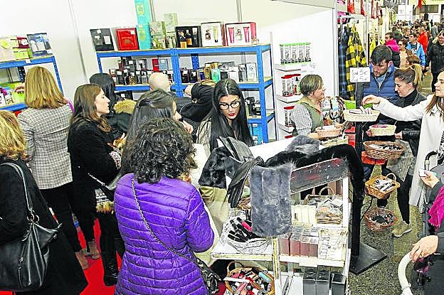 Los primeros visitantes de la Feria del Stock observan los artículos expuestos en uno de los establecimientos comerciales participantes.