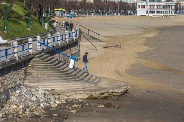 Queda a la vista la plataforma de la escalera de acceso próxima a Piquío y un montón de piedras olvidadas tras las obras del colector de aguas residuales que discurre bajo ese tramo del paseo